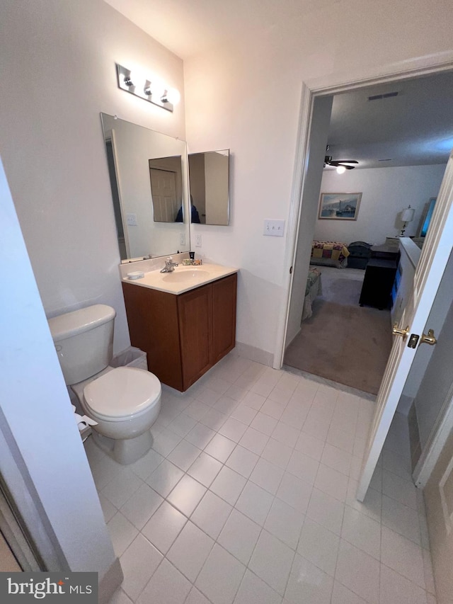 bathroom featuring toilet, tile patterned floors, a ceiling fan, and vanity