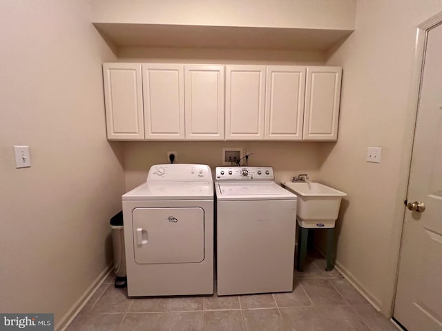 laundry room featuring cabinet space, a sink, washer and clothes dryer, and baseboards