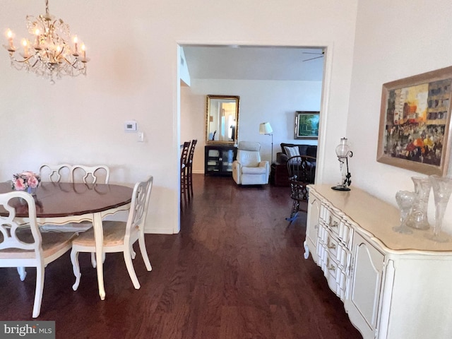 dining room with dark wood-style flooring and an inviting chandelier