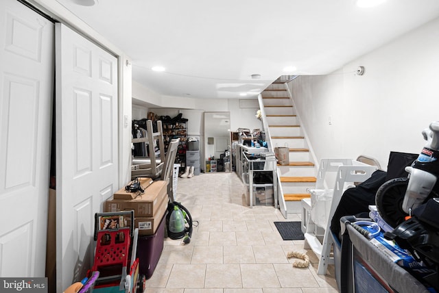 finished below grade area with light tile patterned floors and stairway