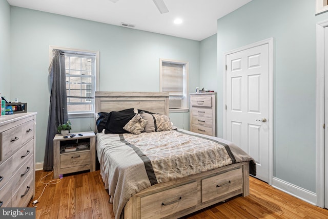 bedroom featuring baseboards, visible vents, and wood finished floors