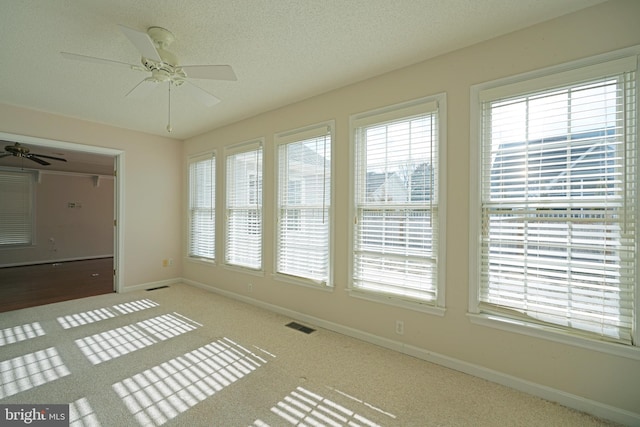 interior space with visible vents and a ceiling fan