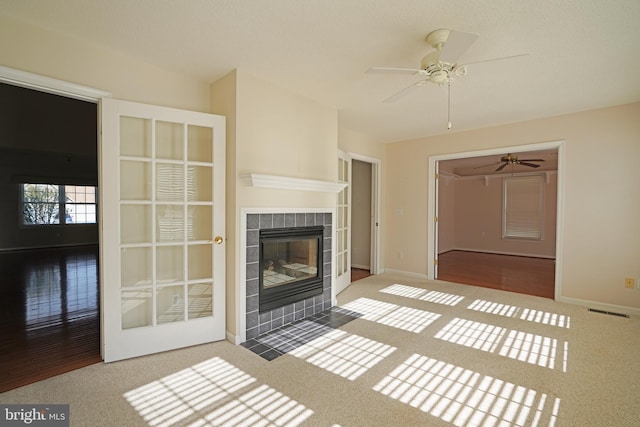 unfurnished living room with a fireplace, carpet flooring, visible vents, and baseboards