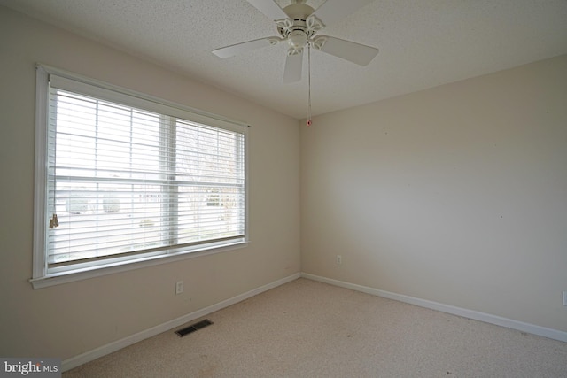 empty room featuring visible vents, baseboards, ceiling fan, carpet, and a textured ceiling