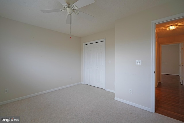 unfurnished bedroom featuring carpet, a closet, ceiling fan, and baseboards