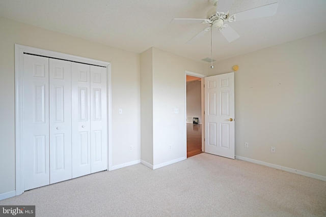 unfurnished bedroom featuring a closet, carpet flooring, a ceiling fan, and baseboards