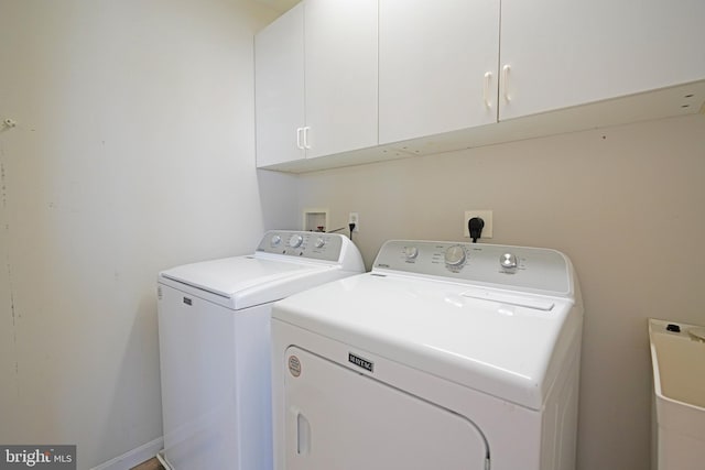 washroom with cabinet space and washer and dryer