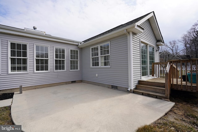 rear view of property featuring crawl space, a patio, and a wooden deck