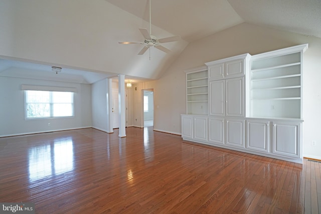 unfurnished living room with baseboards, lofted ceiling, hardwood / wood-style flooring, ceiling fan, and ornate columns