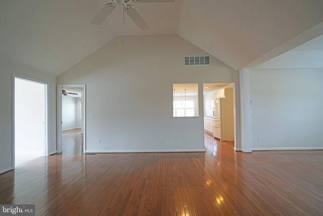 empty room featuring a ceiling fan, visible vents, high vaulted ceiling, and wood finished floors