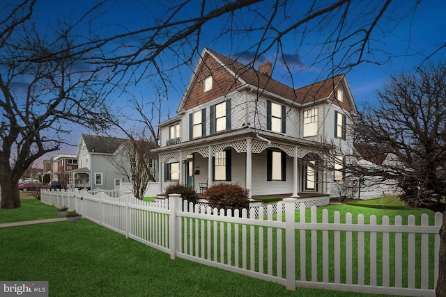 view of side of home with a fenced front yard, a yard, and a chimney