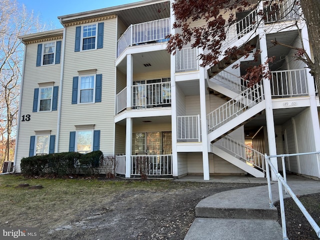 view of building exterior featuring stairs and cooling unit