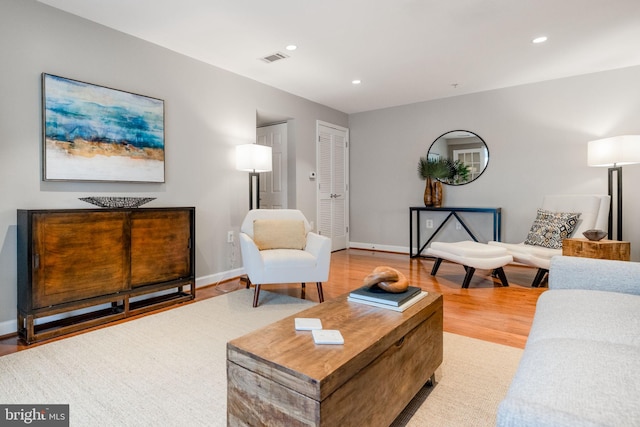 living room featuring baseboards, recessed lighting, visible vents, and light wood-style floors