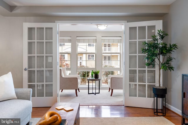 doorway to outside featuring french doors, wood finished floors, and baseboards