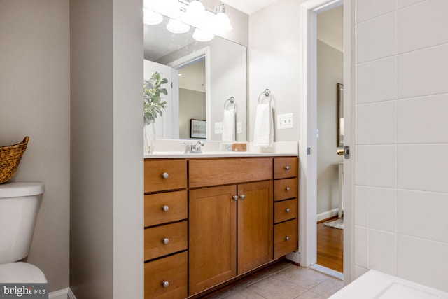 bathroom featuring toilet, tile patterned flooring, and vanity