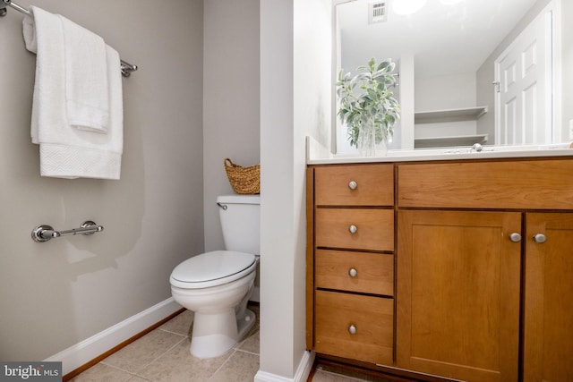 bathroom featuring toilet, tile patterned flooring, baseboards, and vanity