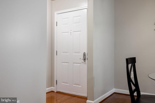 foyer with baseboards and wood finished floors