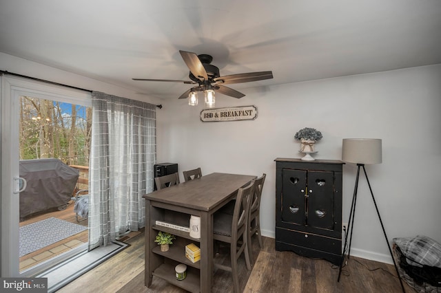 dining area featuring baseboards, wood finished floors, and a ceiling fan