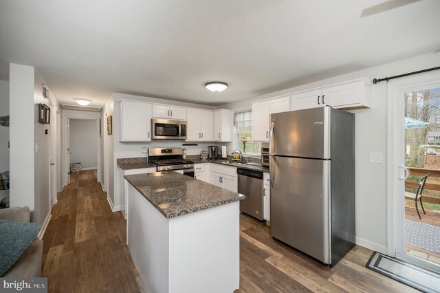 kitchen featuring a sink, white cabinetry, appliances with stainless steel finishes, dark wood finished floors, and plenty of natural light