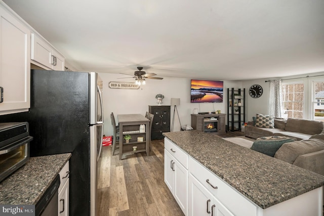 kitchen featuring open floor plan, white cabinets, wood finished floors, and a ceiling fan
