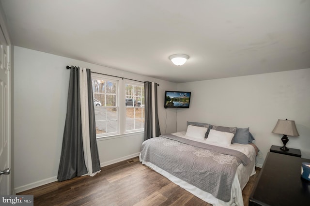 bedroom featuring visible vents, baseboards, and wood finished floors