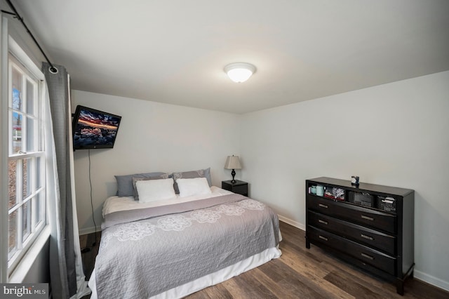 bedroom with dark wood-style floors and baseboards