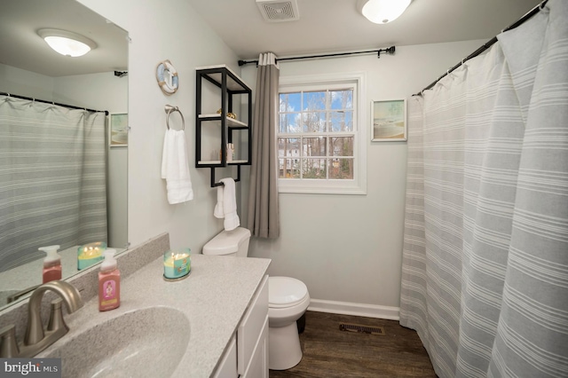 full bathroom featuring vanity, toilet, baseboards, visible vents, and wood finished floors