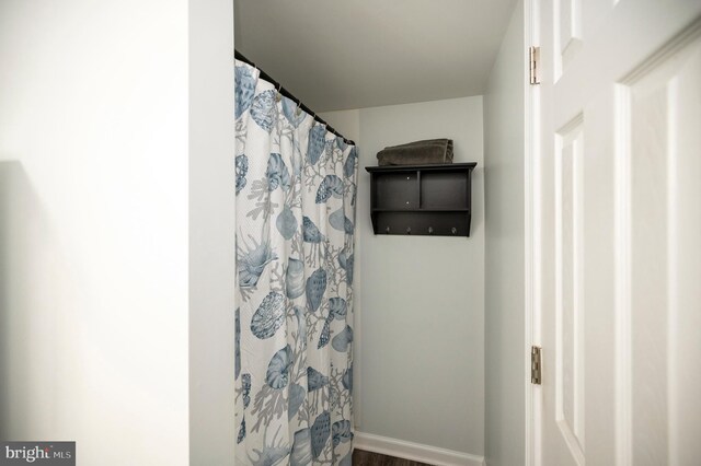 full bathroom featuring curtained shower and baseboards