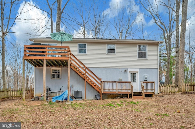 back of property with fence, cooling unit, stairway, and a deck