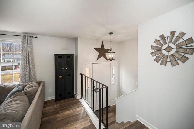 stairway featuring baseboards, wood finished floors, and a chandelier