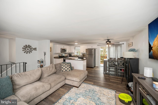 living area featuring ceiling fan and dark wood finished floors
