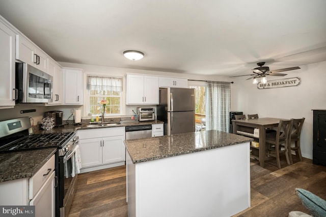 kitchen with dark wood-style flooring, white cabinets, a sink, and stainless steel appliances