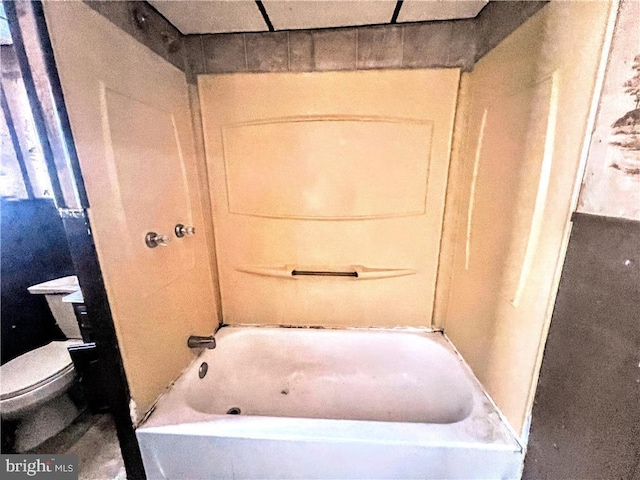 bathroom featuring a tub to relax in and toilet