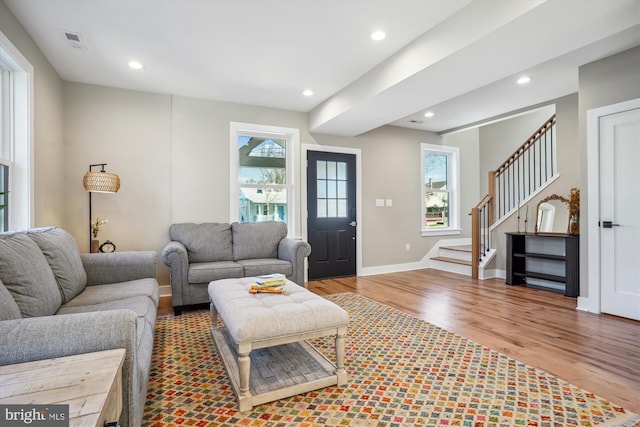 living area featuring stairs, recessed lighting, wood finished floors, and visible vents