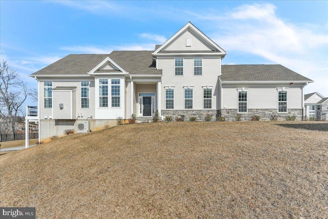 traditional home featuring stone siding, roof with shingles, and a front yard