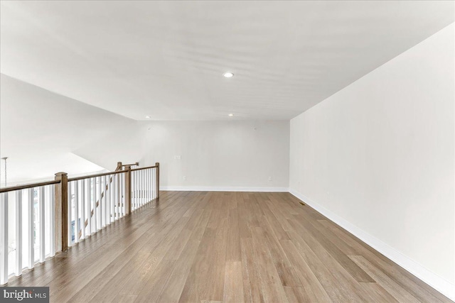 unfurnished room with light wood finished floors, recessed lighting, and baseboards