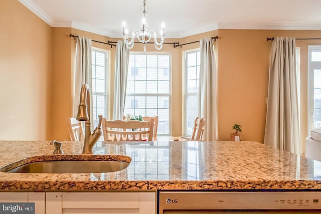 kitchen featuring light stone countertops, a sink, a wealth of natural light, and crown molding