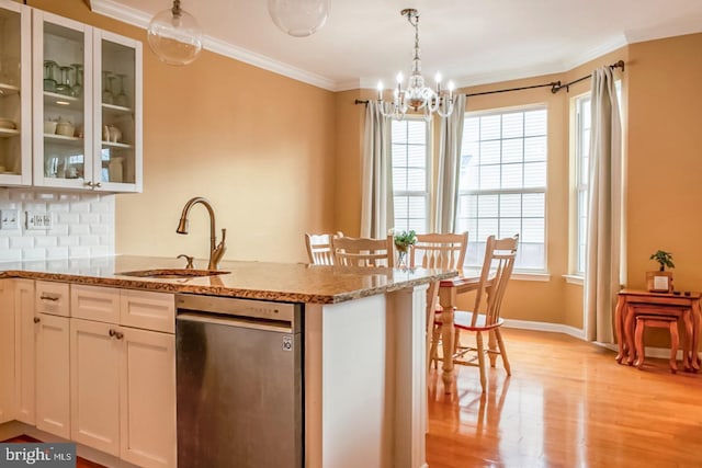 kitchen featuring backsplash, plenty of natural light, a sink, and crown molding