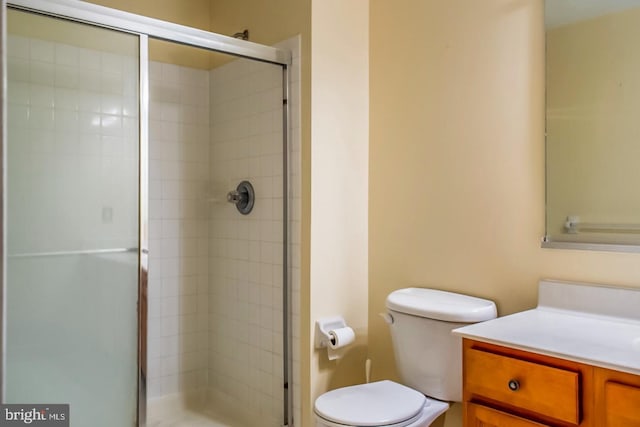 full bath with vanity, a shower stall, and toilet