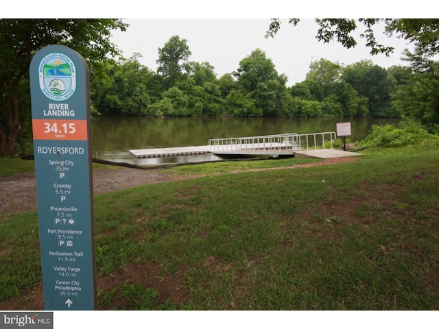 dock area with a water view and a lawn