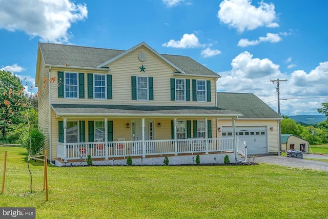 colonial house featuring a front lawn, covered porch, driveway, and an attached garage