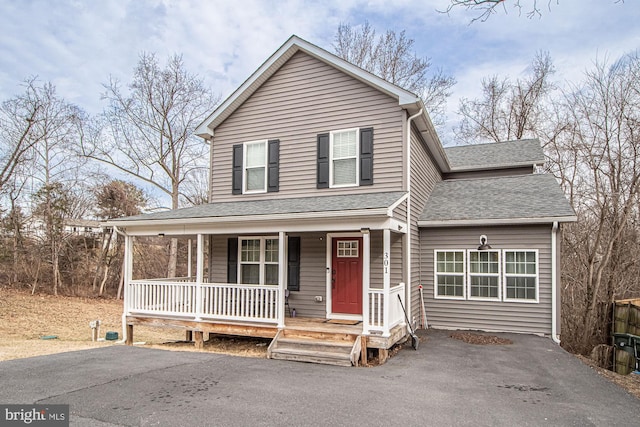 view of front of property featuring a porch, a shingled roof, and driveway