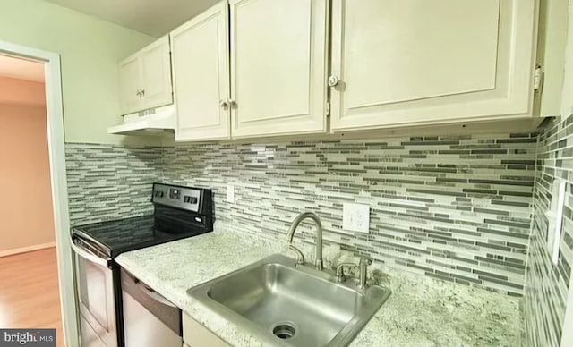 kitchen featuring under cabinet range hood, stainless steel appliances, a sink, white cabinetry, and backsplash