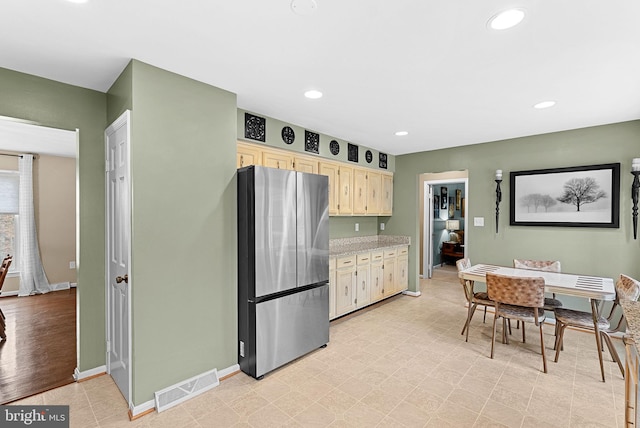 kitchen with recessed lighting, visible vents, light brown cabinetry, freestanding refrigerator, and baseboards