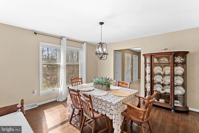 dining area featuring wood finished floors, visible vents, and baseboards