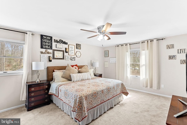 bedroom with a ceiling fan, light carpet, and baseboards