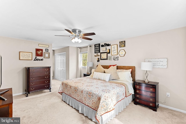 bedroom featuring light carpet, a closet, and baseboards