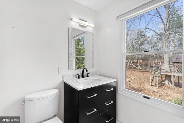 half bathroom with vanity and toilet