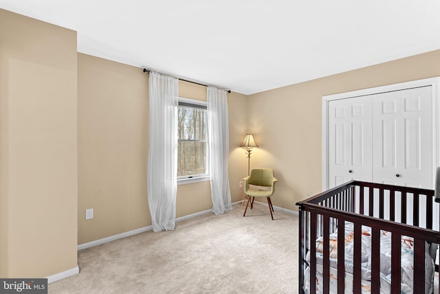 carpeted bedroom featuring a closet and baseboards