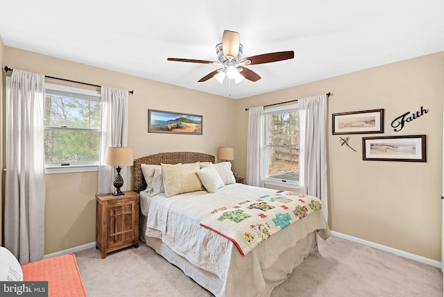 bedroom with light carpet, multiple windows, and baseboards